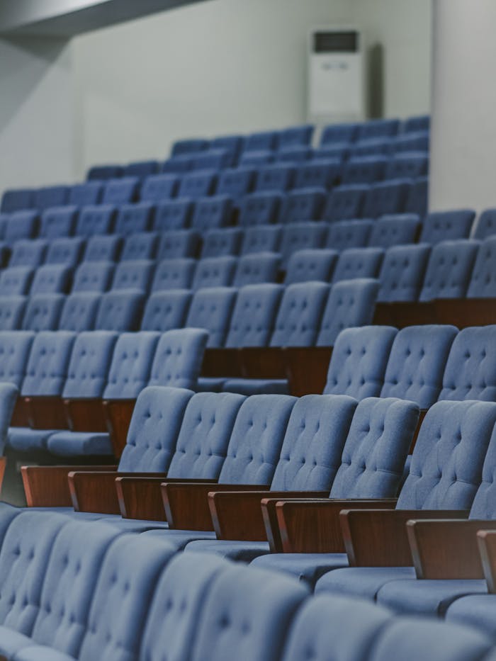 Blue upholstered chairs in an empty conference room, set for an event.